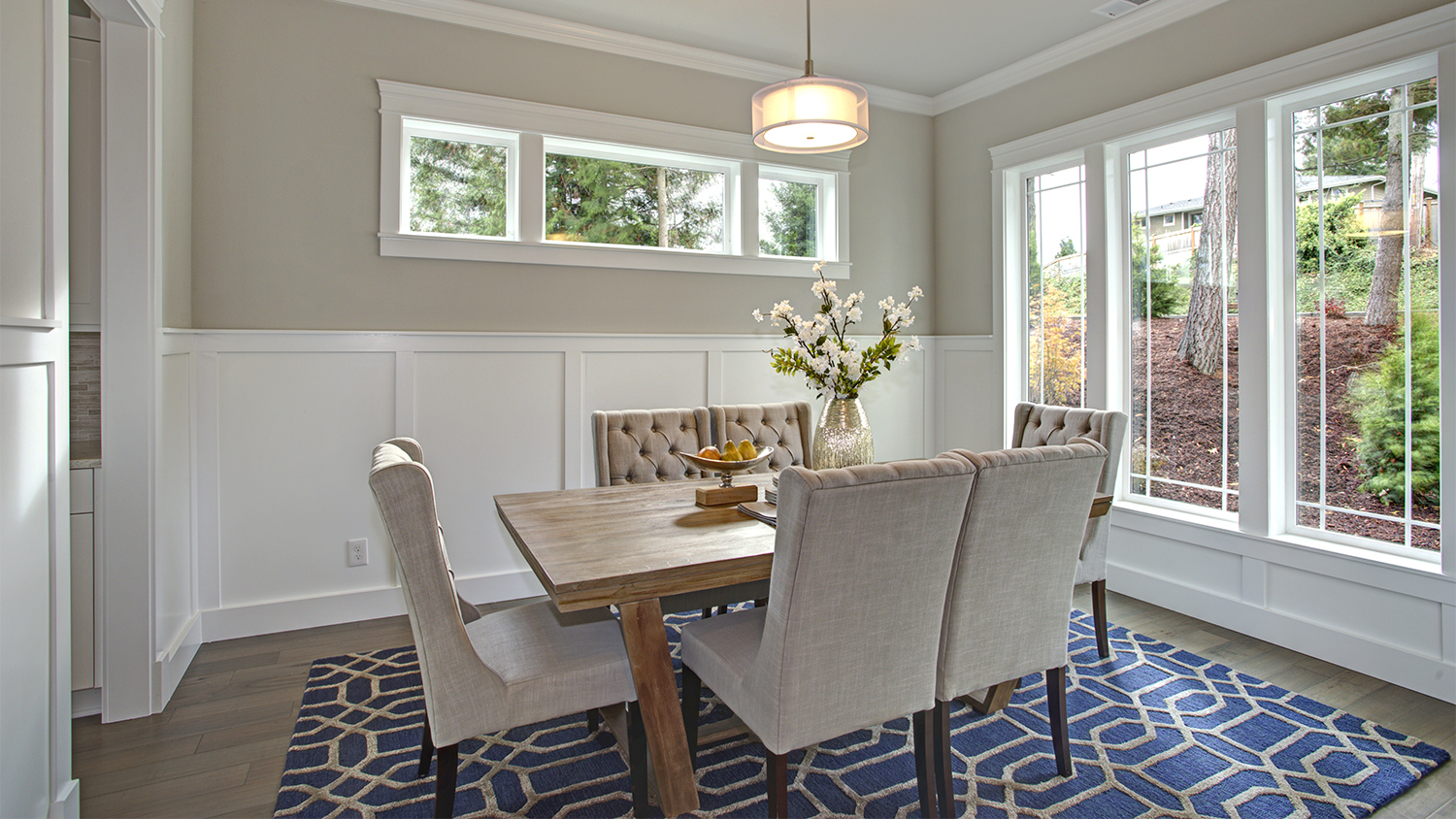 beige dining room with blue rug 